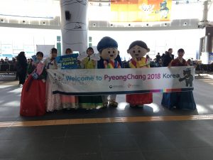 People holding welcome PyeongChang 2018 sign