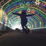 girl jumping in tunnel of lights