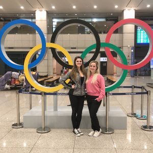 Two girls in front of Olympic rings
