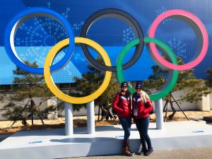 Two girls in front of Olympic rings